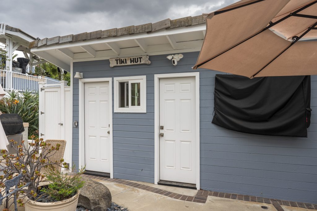 Tiki Hut exterior with twin doors beside pool patio