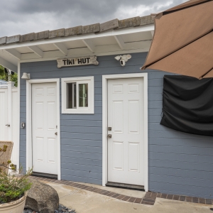 Tiki Hut exterior with twin doors beside pool patio