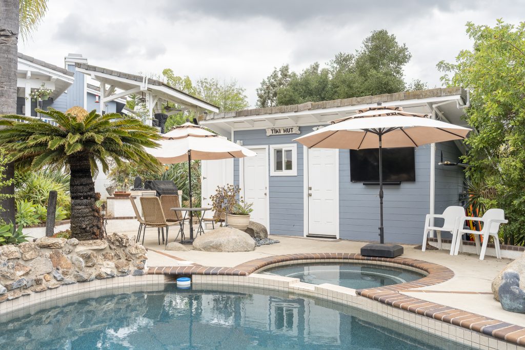 Poolside view toward Tiki Hut with umbrellas and spa