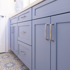 Low angle of blue vanity with Amerock Kane pulls over Ethnic patterned floor tile