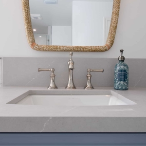 Undermount sink with chrome widespread faucet and quartz countertop detail