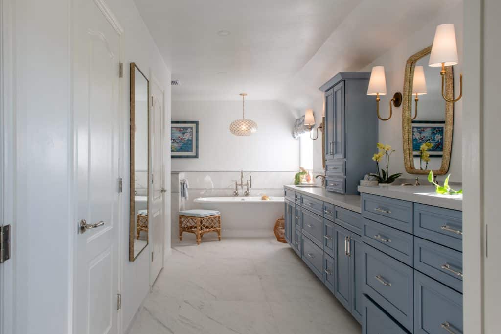 Wide view of El Cajon primary bathroom remodel with blue double vanity and freestanding soaking tub