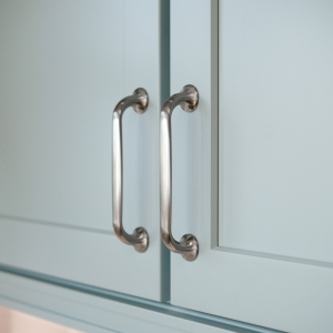 Close-up of Top Knobs Oculus cabinet pulls on custom blue shaker cabinet doors