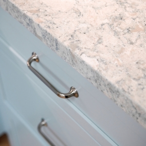 Cambria Montgomery quartz countertop edge with Top Knobs cabinet pulls on blue drawers