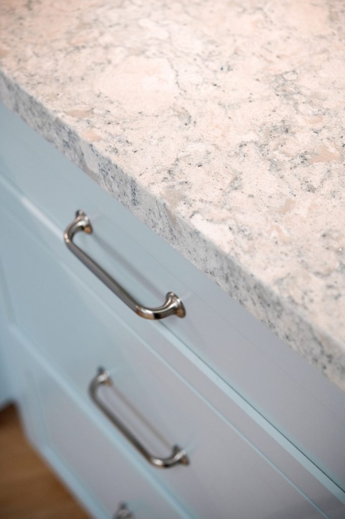 Cambria Montgomery quartz countertop edge with Top Knobs cabinet pulls on blue drawers