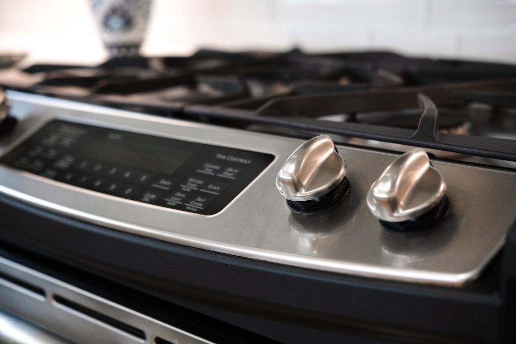 Close-up of stainless range knobs and cooktop detail in remodeled kitchen