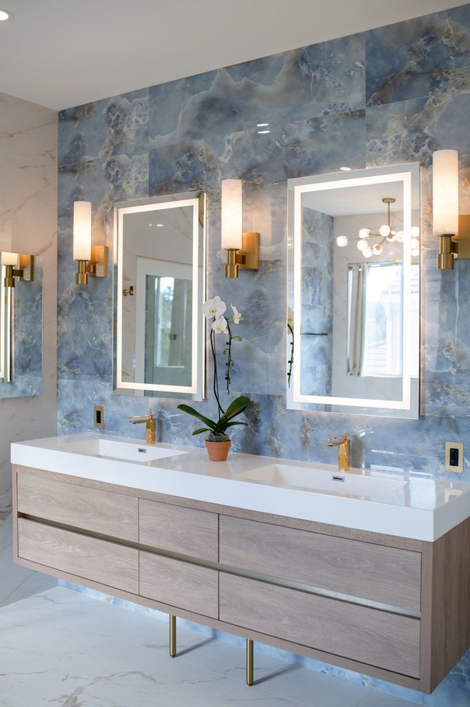 Full view of a modern double vanity with oak cabinetry and a blue onyx-look tile wall