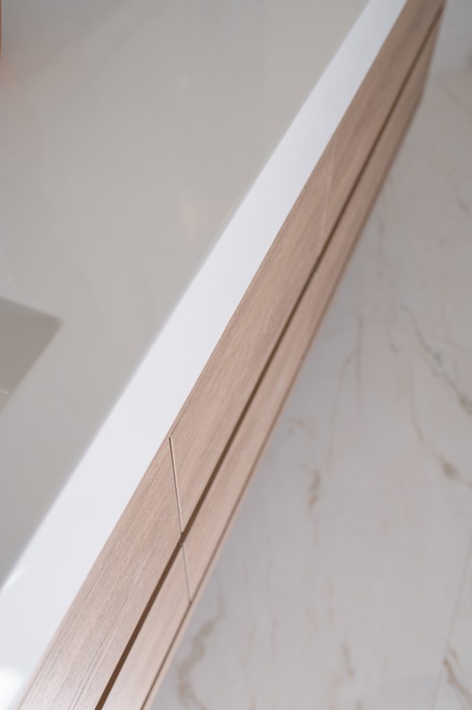 Close-up detail of a floating light-oak vanity with clean modern drawer lines