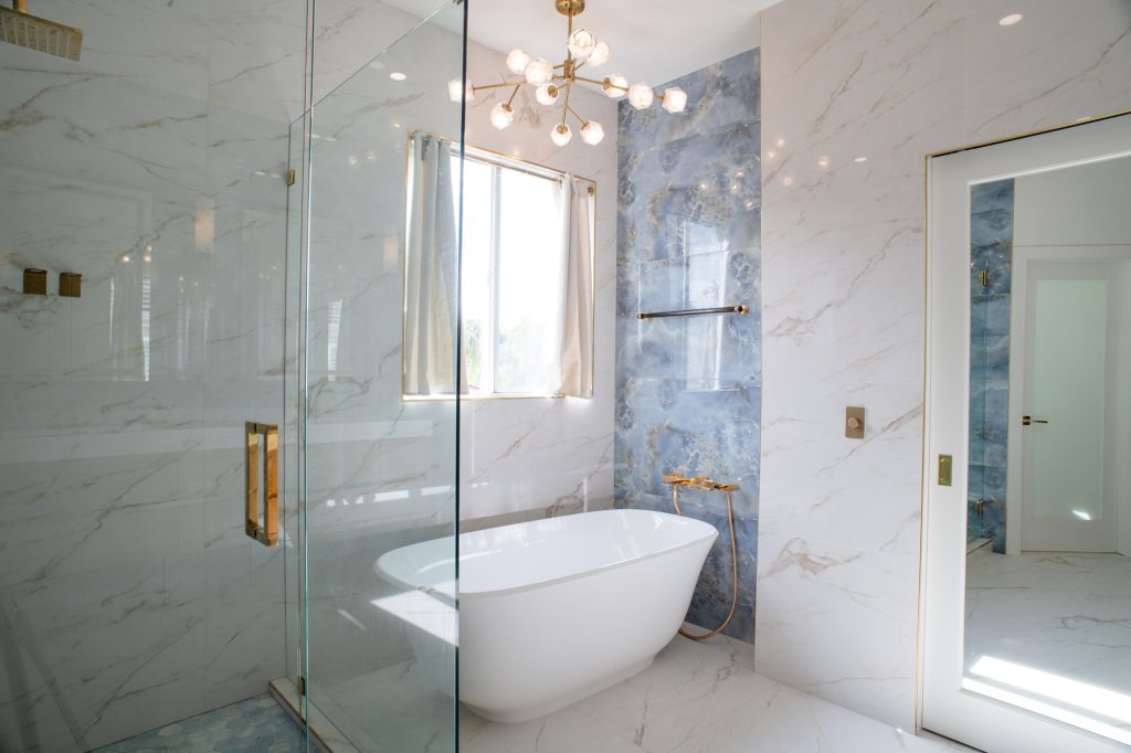 Luxury bathroom with blue onyx-look tile, glass shower, and freestanding tub