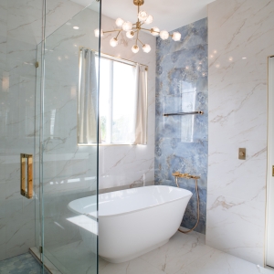 Luxury bathroom with blue onyx-look tile, glass shower, and freestanding tub