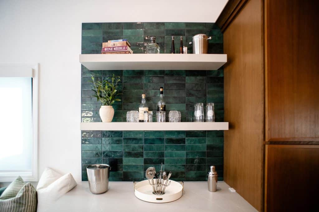 Beverage station with green tile and floating shelves