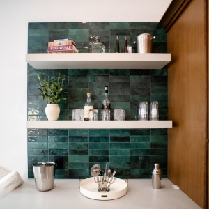Beverage station with green tile and floating shelves