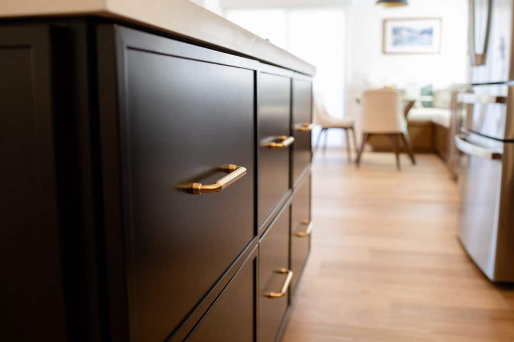 Dark island cabinetry with brass hardware