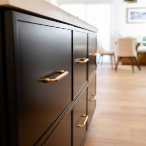 Dark island cabinetry with brass hardware