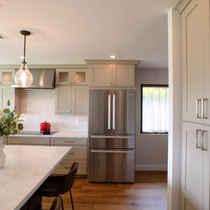 Remodeled kitchen with large island, induction cooktop, and tall pantry cabinets