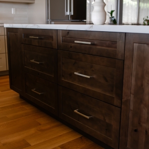 Stained knotty alder kitchen island with white countertop and warm wood flooring