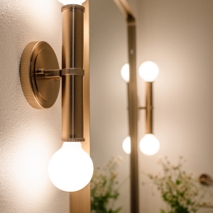 Brass wall sconce in the hall bathroom