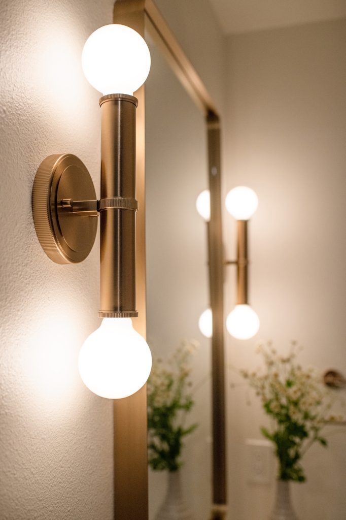 Brass wall sconce in the hall bathroom