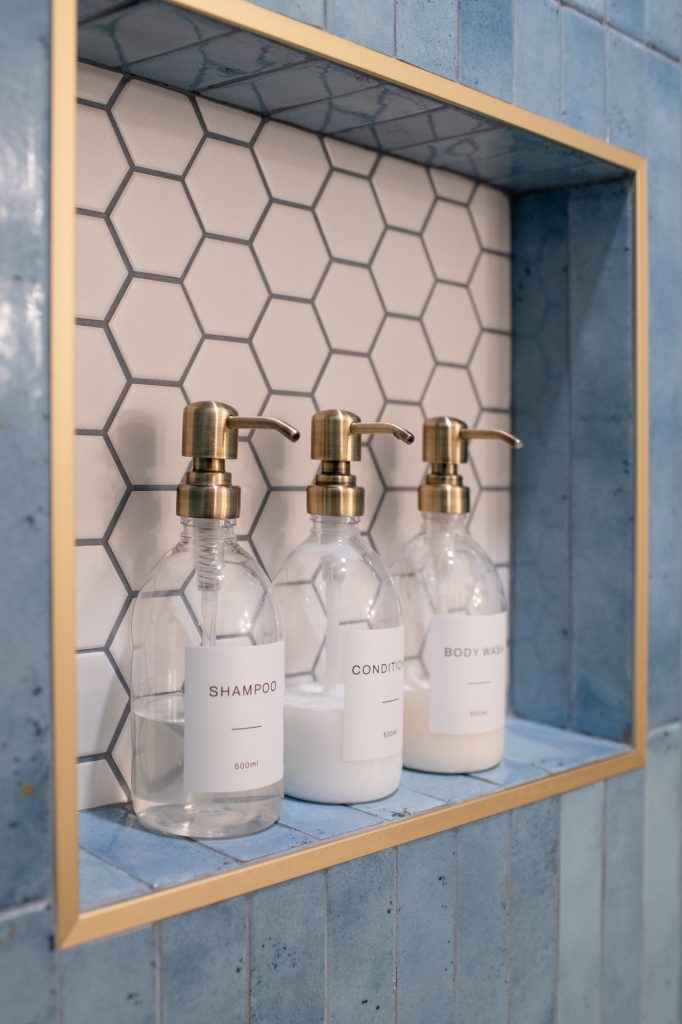 Hall bathroom shower niche with white hex tile