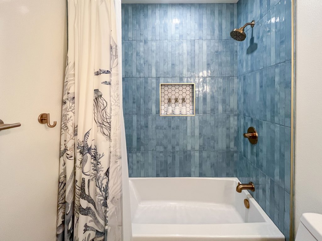 Hall bathroom tub and shower with blue wall tile