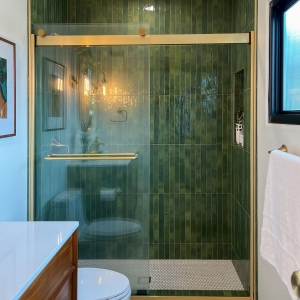 Master bathroom shower with green tile and glass enclosure