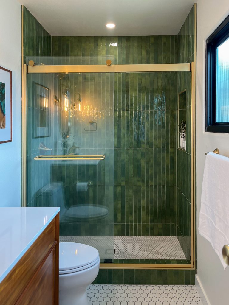 Master bathroom shower with green tile and glass enclosure