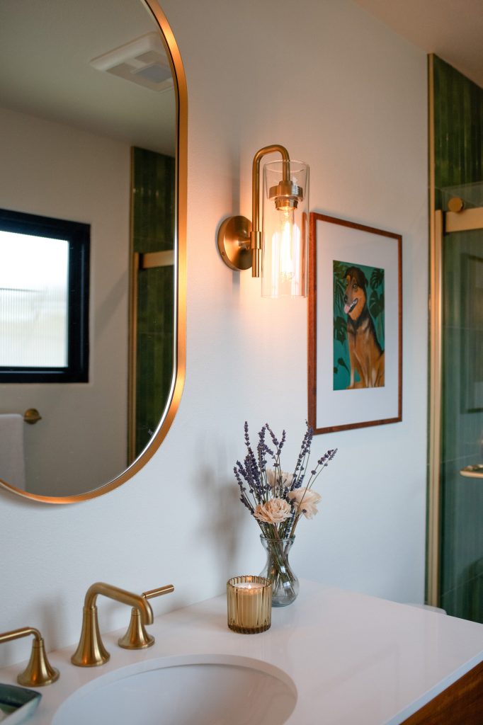 Primary bathroom sconce, mirror, and artwork detail