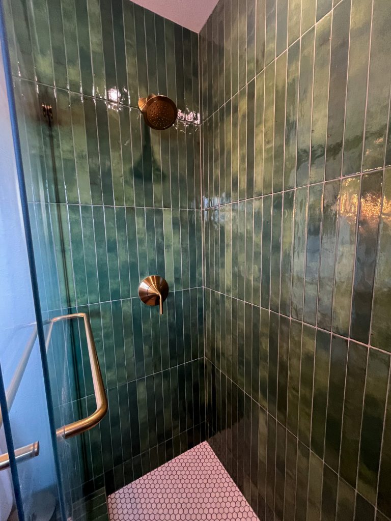 Inside the primary bathroom shower with green tile