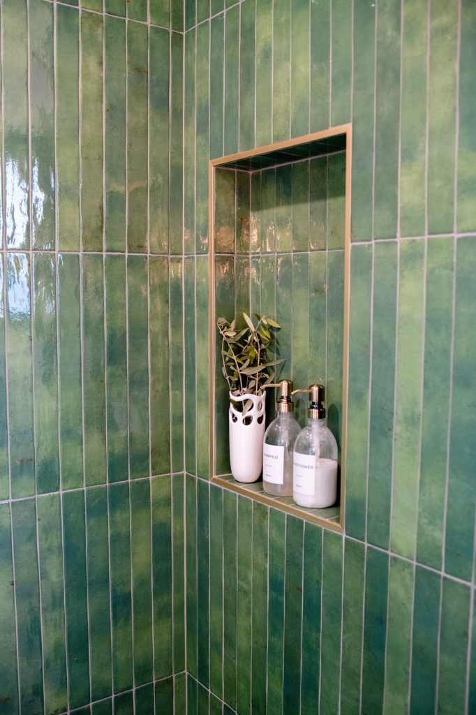 Primary bathroom shower niche with green tile