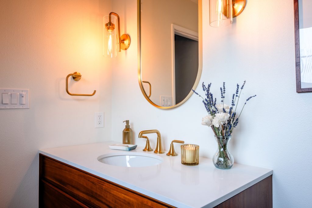 Styled primary bathroom vanity with brass accents