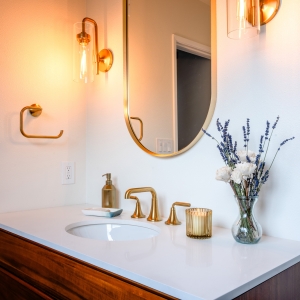 Styled primary bathroom vanity with brass accents