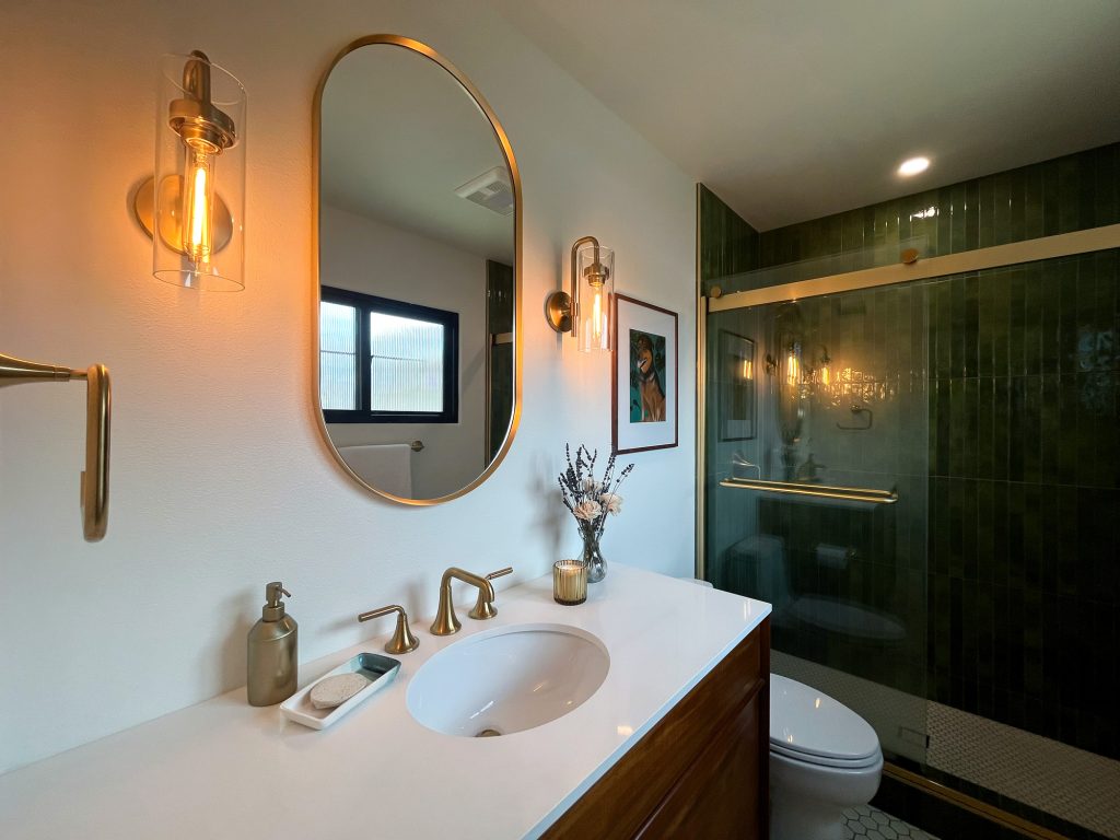 Primary bathroom vanity beside the green tiled shower