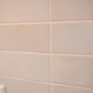 Close-up of the glossy cream ceramic backsplash tile in a horizontal straight set