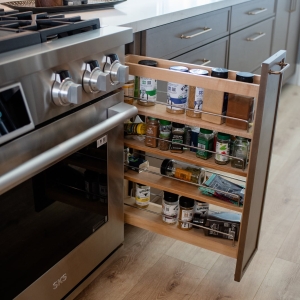 Four-tier pull-out spice rack in the cabinet beside the range