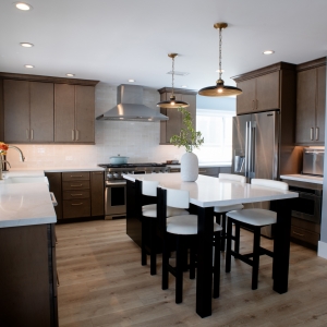 Kitchen looking toward the tiled fireplace, with the island and stainless range in view
