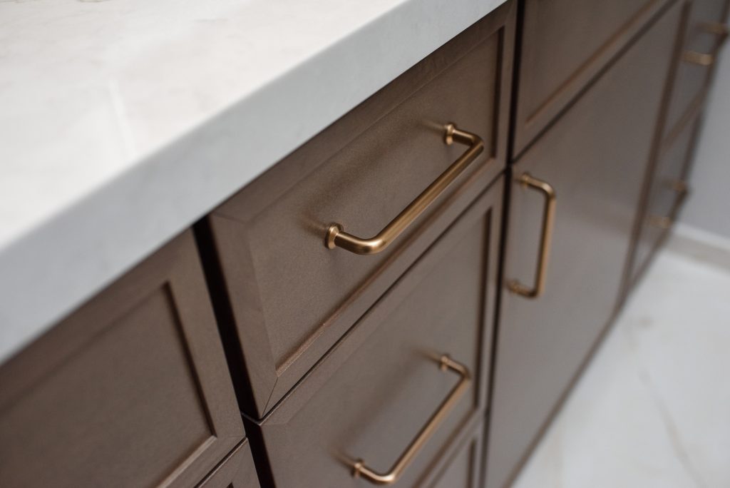 Brass bar pull on a Maple Latte drawer front below the quartz countertop edge