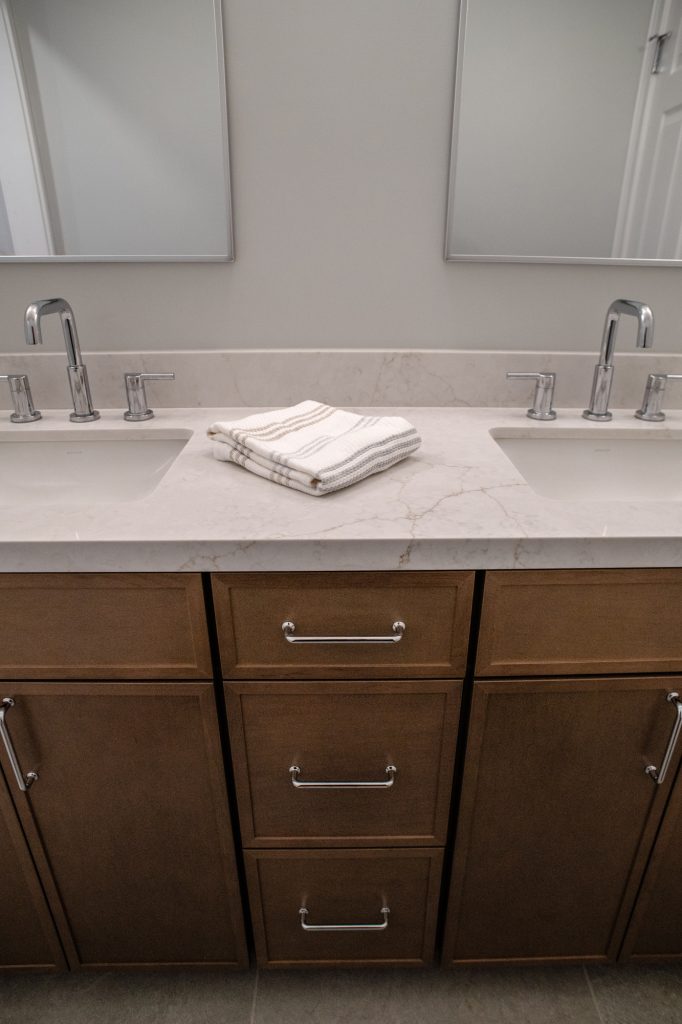 Vanity front with chrome pulls on Maple Latte doors and drawers below the quartz top