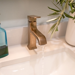 Delta single-handle faucet in a bronze finish running water into an undermount sink