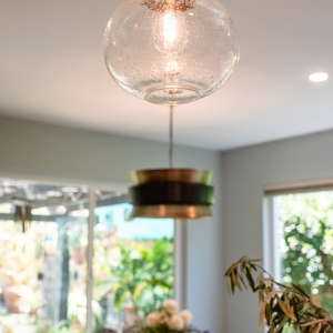 Glass globe pendant in the foreground with the banquette drum pendant behind