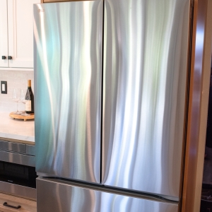 Stainless French door refrigerator set into the maple cabinet surround