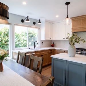 Sink wall with two adjustable sconces above the window, island in the foreground