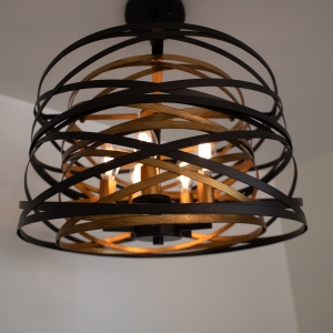 Drum chandelier with crisscrossing black and gold metal bands