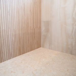 Hexagon porcelain mosaic shower floor meeting slat and onyx-look wall tile