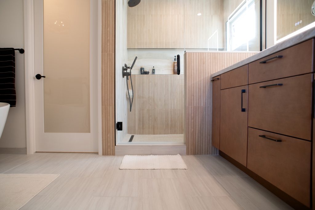 Walk-in shower entry and separate water closet with a laminated glass door in a Point Loma master bath