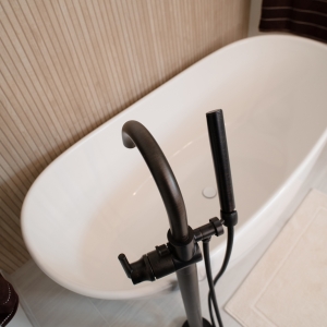 Dark bronze tub filler with handheld sprayer beside the tub