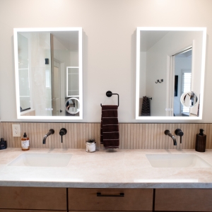 Maple Cider vanity with dark pulls, quartz top, and two lighted medicine cabinets