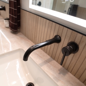 Wall-mounted faucet in dark bronze over an undermount sink