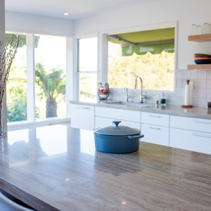 Blue Dutch oven sitting on the porcelain island surface, sink wall in the background