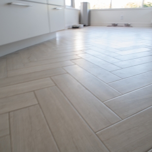 Limestone-look porcelain floor tile laid in a herringbone pattern