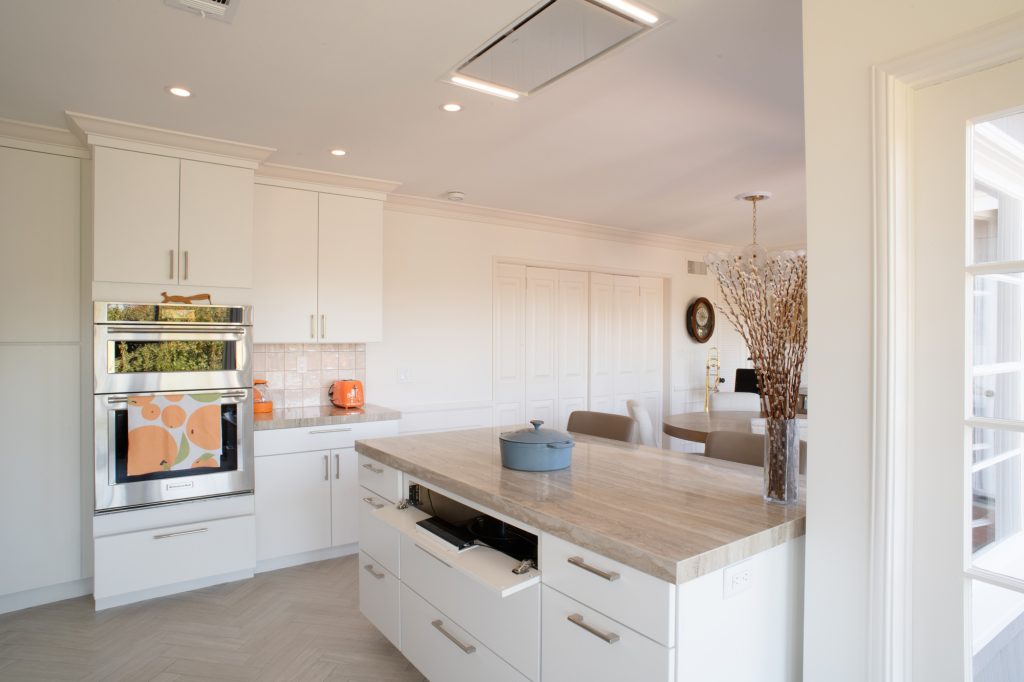 Hidden induction cooktop controls mounted inside a kitchen cabinet in a Point Loma remodel